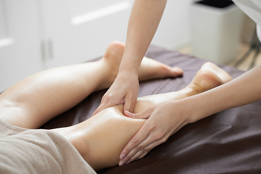 Women receiving foot massage in a bright beauty salon