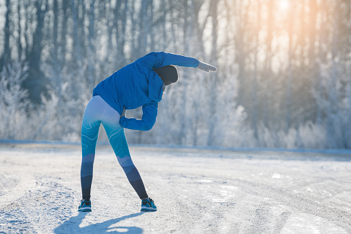 Runner stretching in winter Park. A healthy way of life